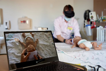 Doctor examining an infant using Augmented Reality for Neonatal Resuscitation