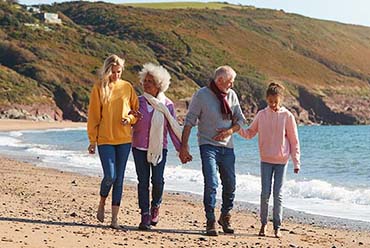 family holding hands walking on beach
